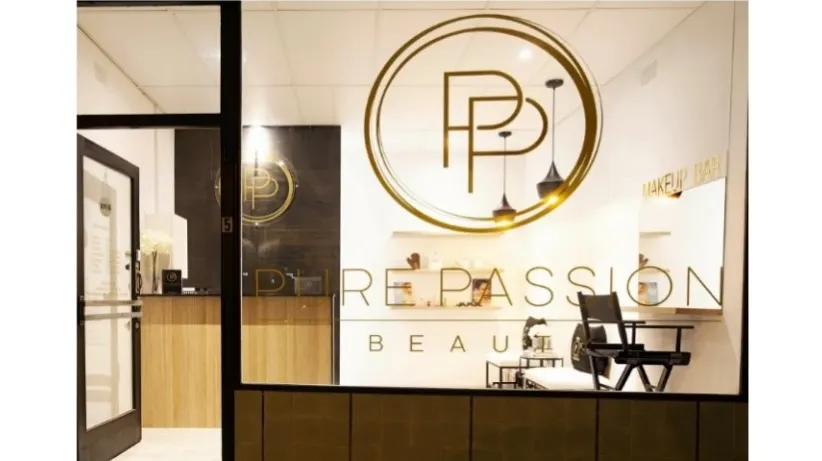 The Pure Passion Beauty shopfront at night, gold PP monogram on the wall